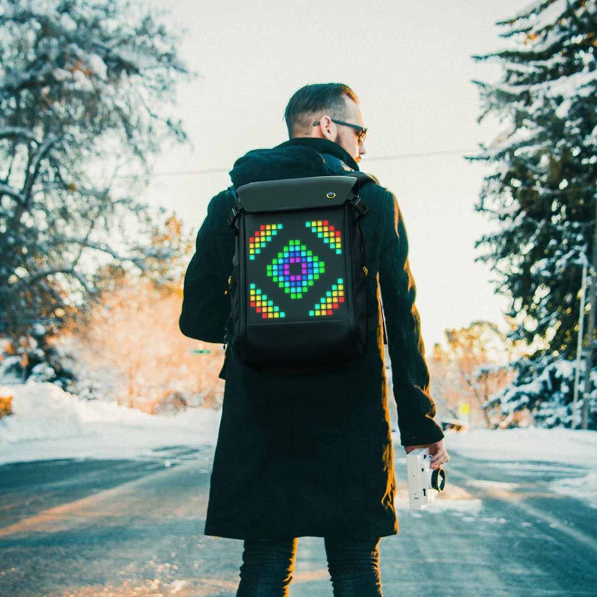 Getragener Divoom Pixoo Backpack-M mit buntem Pixel-Display im winterlichen Outdoor-Alltag